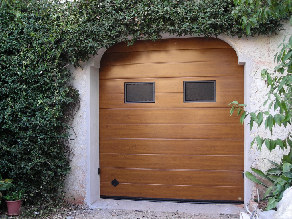 Porta sezionale per garage simil legno con oblò