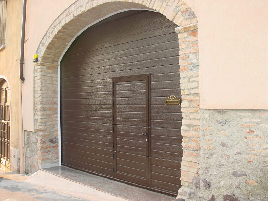 Porta per garage sezionale con porta pedonale a soglia ribassata e cassetta delle lettere integrata